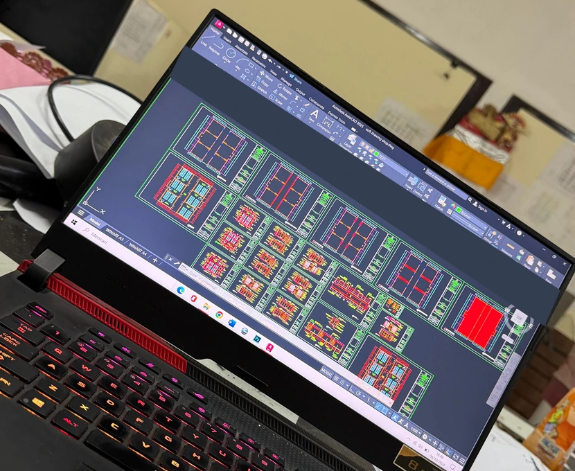 Gambar arsitektur terbuka di AutoCAD pada laptop; tab berisi identitas berkas telah disamarkan.